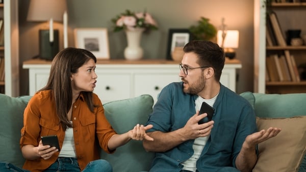 Young couple having an argument over suspicious text messages on boyfriend's phone. (Image: Getty Images)