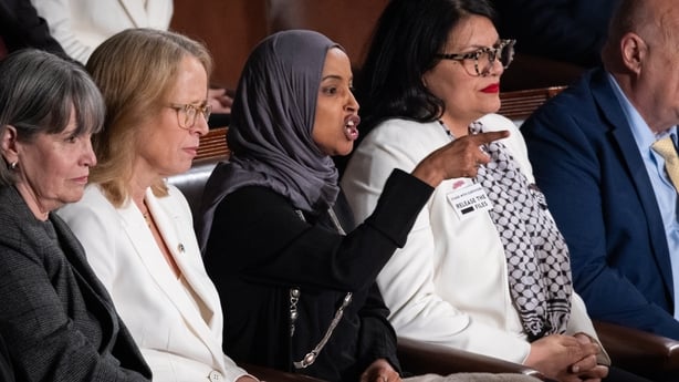 four women sit side by side with one woman wearing a head covering gesturing as she speaks