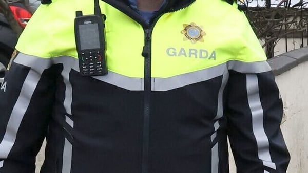 view of a garda in uniform with a radio attached to his jacket