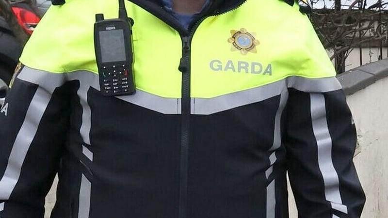 view of a garda in uniform with a radio attached to his jacket