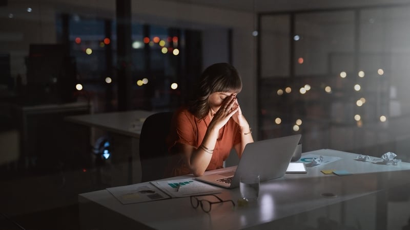 Shot of a young businesswoman looking stressed out while working on a laptop in an office at night