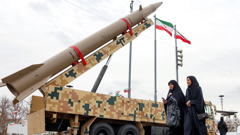Women walk past a ballistic missile launch vehicle in Tehran in Iran.