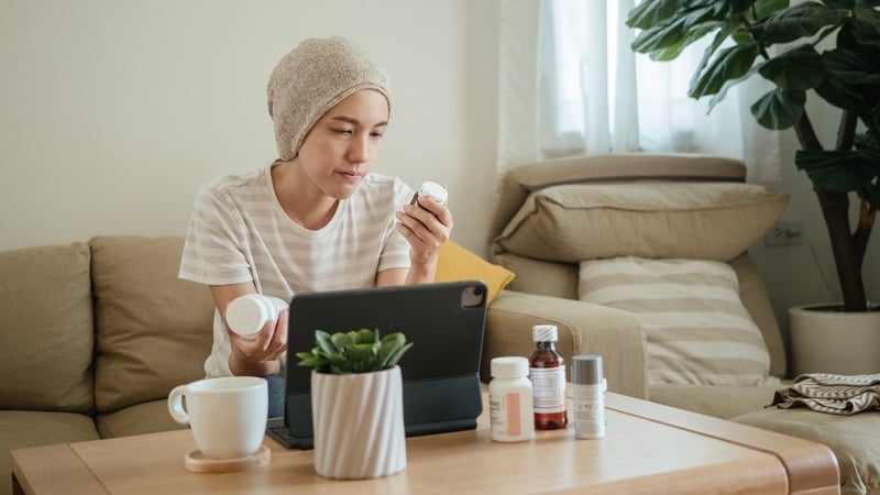 A Woman with cancer video call with doctor on digital tablet and wearing a bandana to hide her hair loss from chemotherapy treatment.