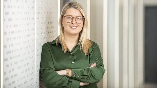 Image of a business woman in a green blouse pictured in an office
