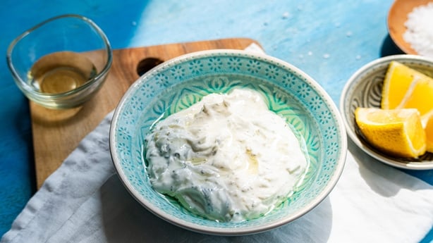 Traditional Greek dip tzatziki on bright blue wooden table background