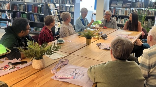 Group of people sit around a table in a library