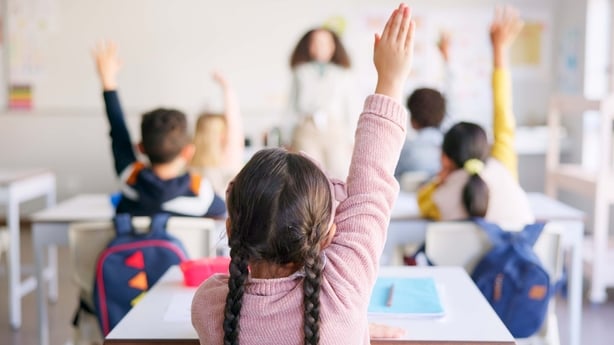 A teacher and pupils in a primary school classroom