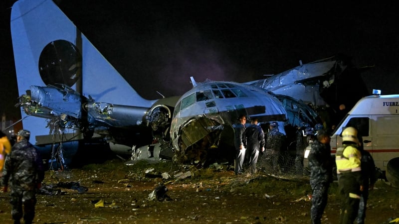 Police stand next to the wreckage of a plane crash