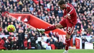 Liverpool's Argentinian midfielder #10 Alexis Mac Allister shoots to score their third goal during the English Premier League football match between Liverpool and West Ham United at Anfield in Liverpool