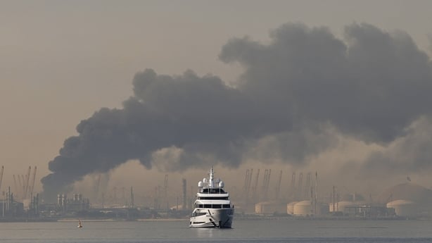 A yacht sails past a plume of smoke rising from the port of Jebel Ali following a reported Iranian strike in Dubai 