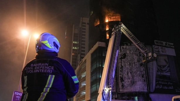 Emergency personnel work to extinguish a fire in a building after an Iranian strike in the capital Manama o