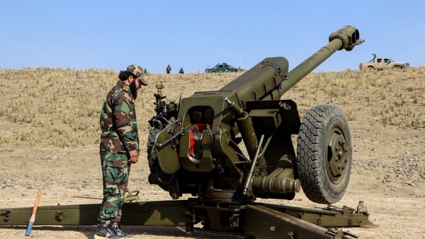 Taliban security personnel stand next to an artillery gun