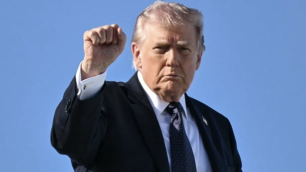 US President Donald Trump gestures as he boards Air Force One