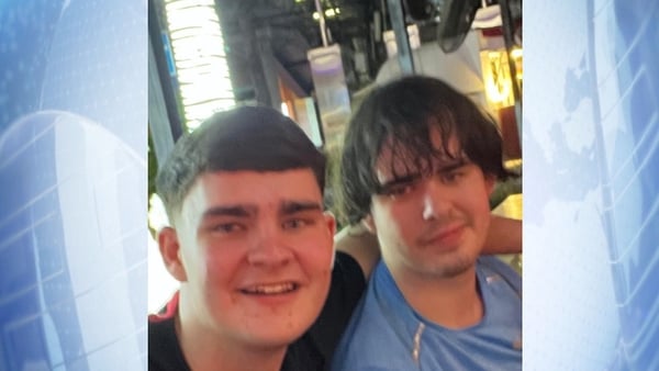 a photo of two young men smiling for the camera on a blue background