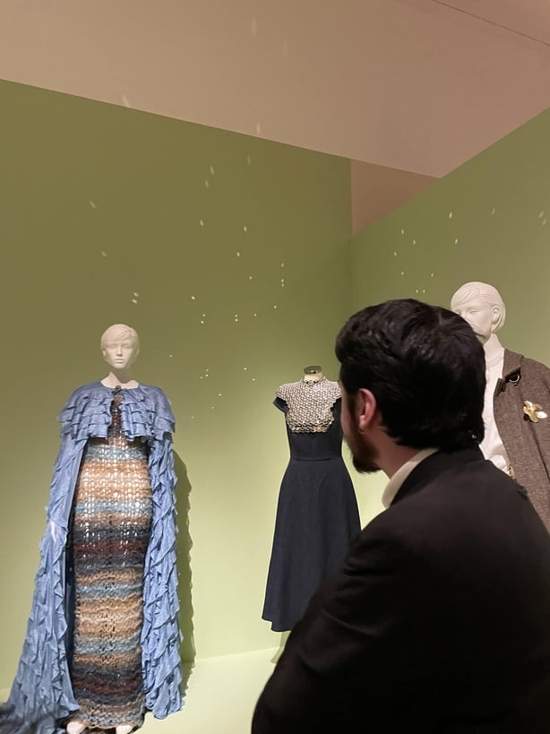 Oran Aurelio looking at his design in the Ashes to Fashion exhibition
