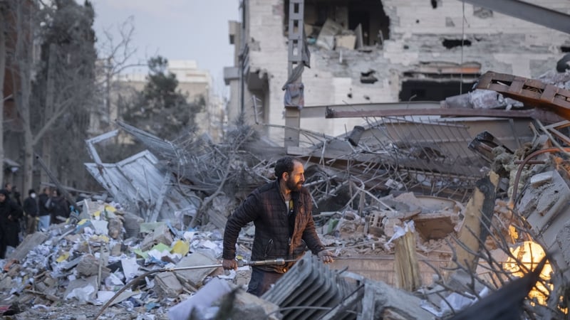 An Iranian man works on the ruins of a police headquarters that is completely destroyed in US-Israeli attacks in Tehran