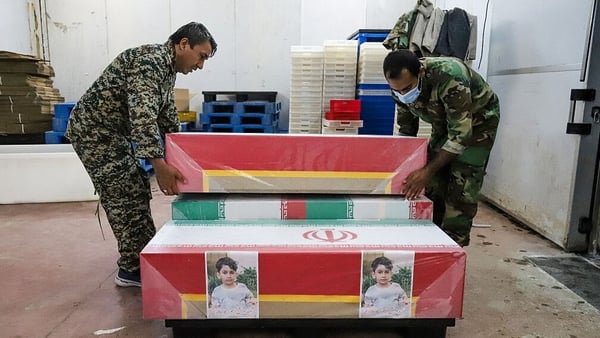 Mourners prepare the coffins of children who were killed in a reported strike on a primary school in Iran’s Hormozgan province for a funeral in Minab