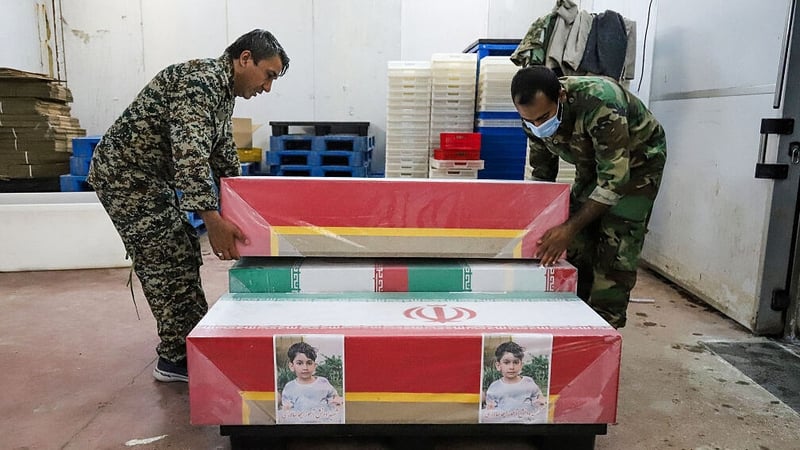 Mourners prepare the coffins of children who were killed in a reported strike on a primary school in Iran’s Hormozgan province for a funeral in Minab