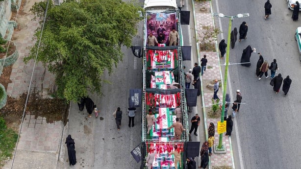 An aerial view of coffins draped with Iranian flags during a funeral ceremony for children in Minab