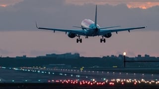 Airplane landing at sunrise.