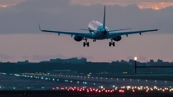 Airplane landing at sunrise.