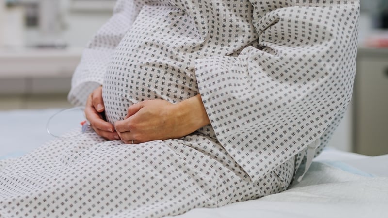 stock image of a pregnant woman wearing a hospital gown