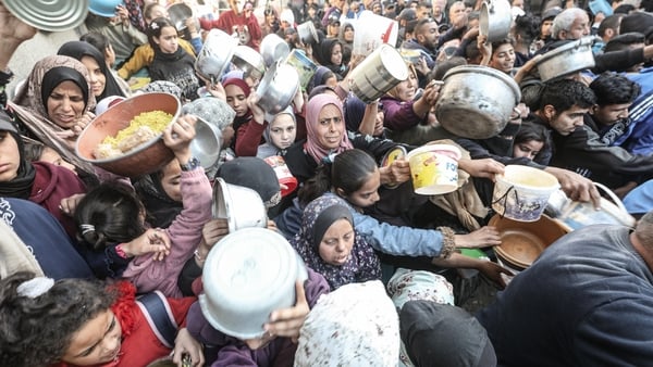 A charity organisation distributes meals to displaced Palestinians at the Nuseirat Refugee Camp
