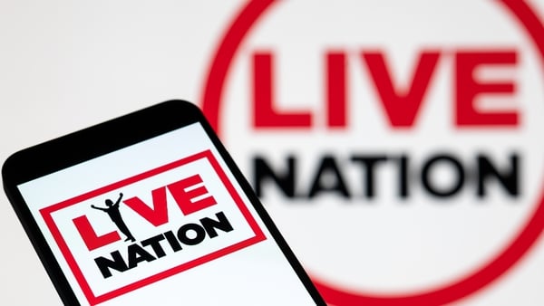 The Live Nation logo is displayed on a mobile phone with the company's branding seen in the background. (Photo by Jonathan Raa/NurPhoto)