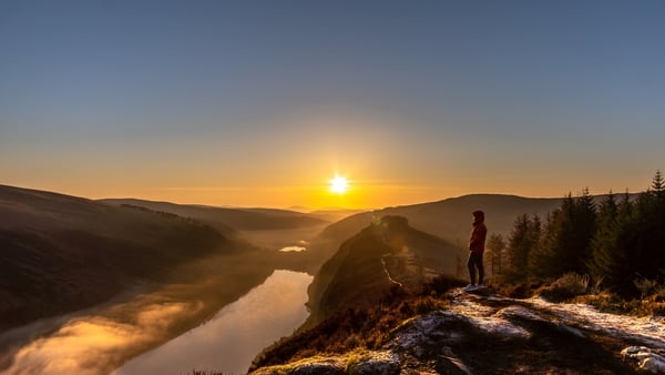 A male standing on the Spink Viewing Spot admiring the sunrise