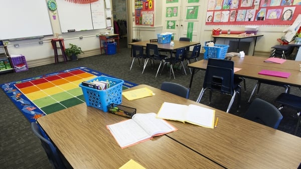 Empty desks with papers in classroom