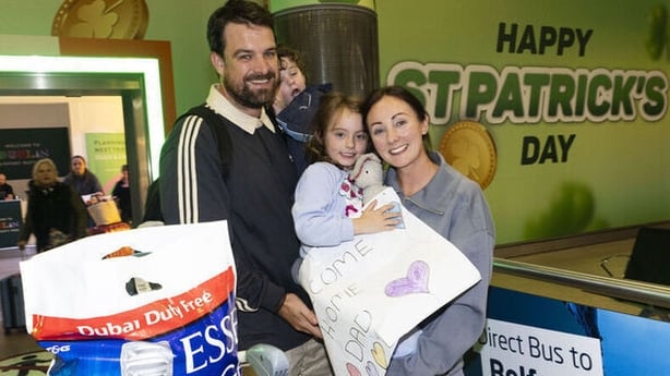 Family including two children smiling at airport