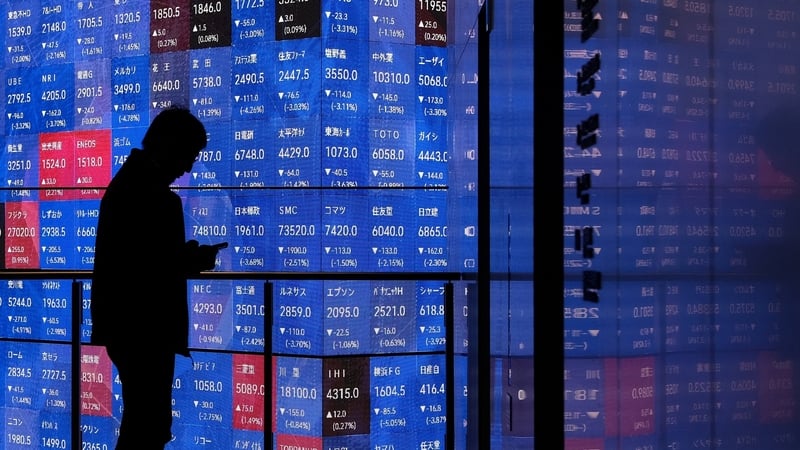 TOPSHOT - A man stands in front of an electronic quotation board displaying the Nikkei 225 stock prices on the Tokyo Stock Exchange in Tokyo on March 2, 2026. Asian stocks dropped in early trade March 2 on the back of fears for the global economy followin