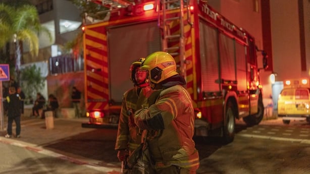 Firefighters and a fire engine with bright lights 