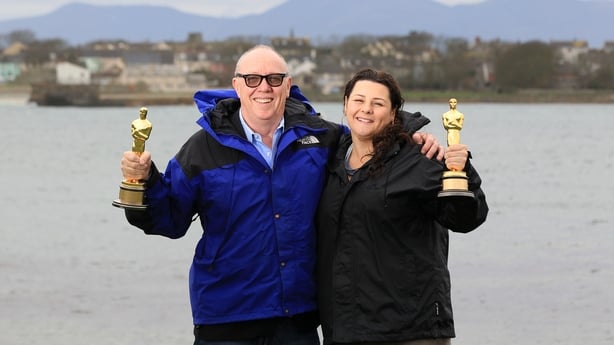 Oscar-winning Belfast director Terry George (L), director of the short film "The Shore" holds up the Oscar he won at the 2012 Academy Awards with his daughter Oorlagh (R) at Coney Island the setting of the film in Coney Island, Northern Ireland on March 6, 2012. 