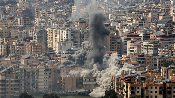 huge plumes of black smoke seen rising in the air over a city skyline