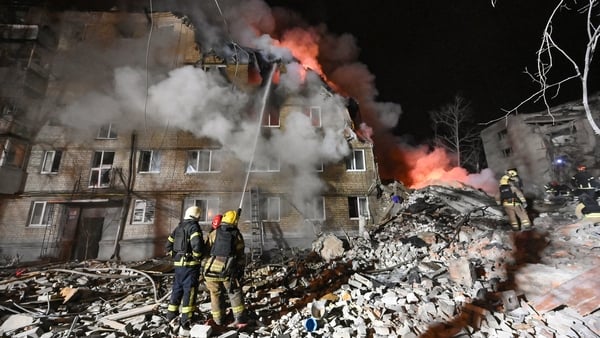Firefighters extinguish a blaze and clear rubble at a five-story residential building in Kharkiv.