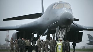 US Military personnel and ground crew talk after disembarking from a US Air Force B-1 Lancer bomber at RAF Fairford in south west England shortly after sunrise on March 7, 2026. Britain's Prime Minister Keir Starmer has given approval for Washington to us