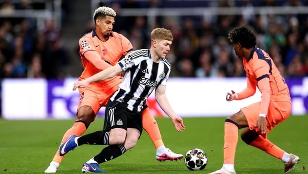 NEWCASTLE UPON TYNE, ENGLAND - MARCH 10: Lewis Hall of Newcastle United is challenged by Ronald Araujo and Lamine Yamal of FC Barcelona during the UEFA Champions League 2025/26 Round of 16 First Leg match between Newcastle United FC and FC Barcelona at St