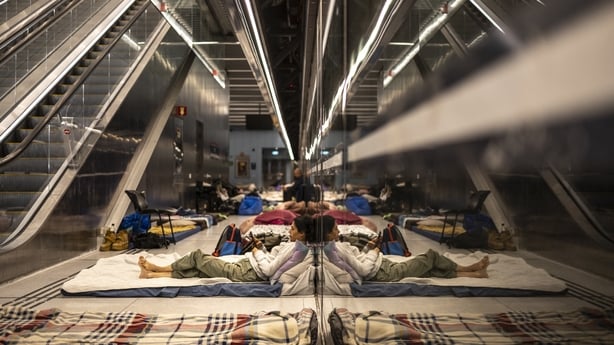 A woman uses a mobile phone as she lies on a mattress