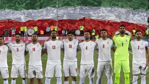 Iranian fans are waving a giant flag while Iran's national soccer team players are standing together before the beginning of the FIFA World Cup 26 AFC qualifying round two group E soccer match against Uzbekistan, at the Azadi (freedom) stadium in Tehran,