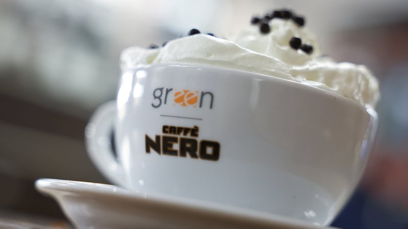 A cup of coffee with cream on top in a cup with the Caffe Nero signage
