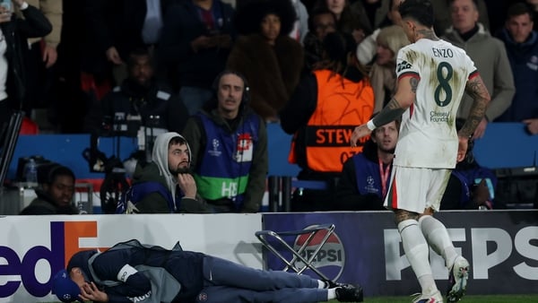 A ball kid lies on the floor after being pushed over by Pedro Neto of Chelsea (not pictured) as Enzo Fernandez of Chelsea walks towards him during the UEFA Champions League 2025/26 Round of 16 First Leg match between Paris Saint-Germain FC and Chelsea FC
