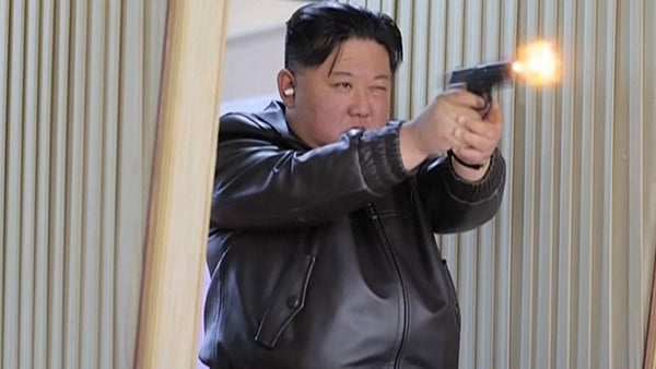North Korean leader Kim Jong Un fires a handgun during a visit to a munitions factory in Pyongyang