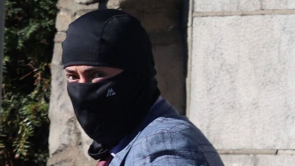 Niall Smith with most of his face and head covered with black material