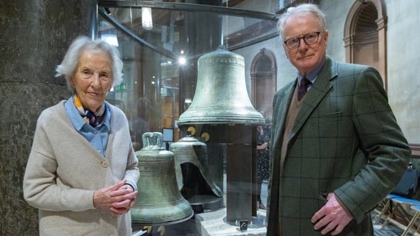 Meryl and Julian Gaisford-St. Lawrence standing next to two large bells