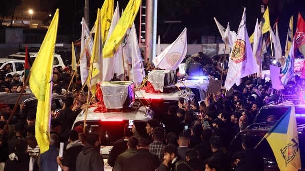 People take part in a funeral procession of members of pro-Iran armed factions in Al‑Qaim, a border town in western Iraq near Syria, on March 12, 2026. Armed groups and officials have said at least 37 people have been killed in Iraq since the start of the Middle East war, according to an AFP tally b