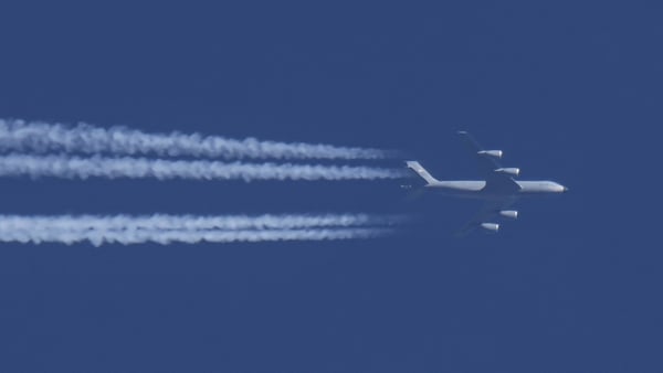 vapour trails are seen in the sky as a Boeing C-135 Stratotanker / Stratolifter military aircraft known as KC-135 of the United States Air Force files overhead