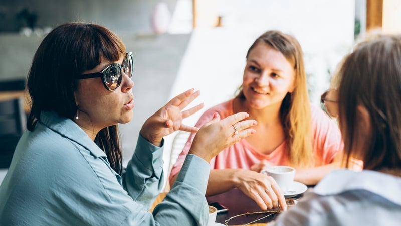 Three female friends sitting at tables, enjoying coffee and gossiping. Meeting for sale and marketing promotion. Business conversations