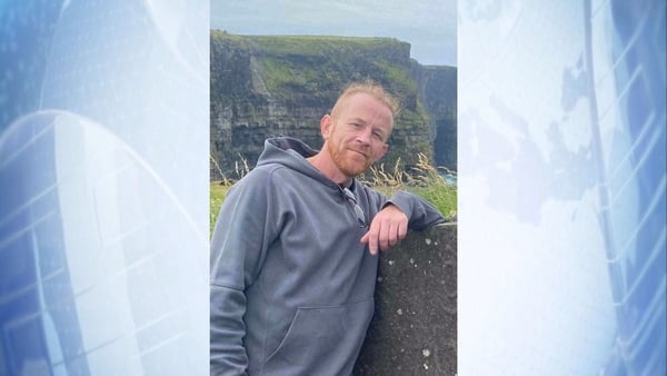 Patrick Gleeson stands by a wall.