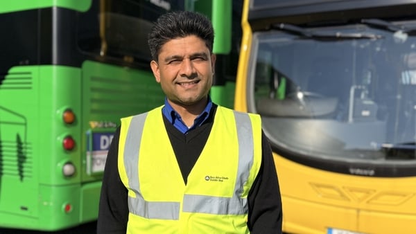 Dublin Bus driver Manpreet Sharma smiles for the camera in front of two busses